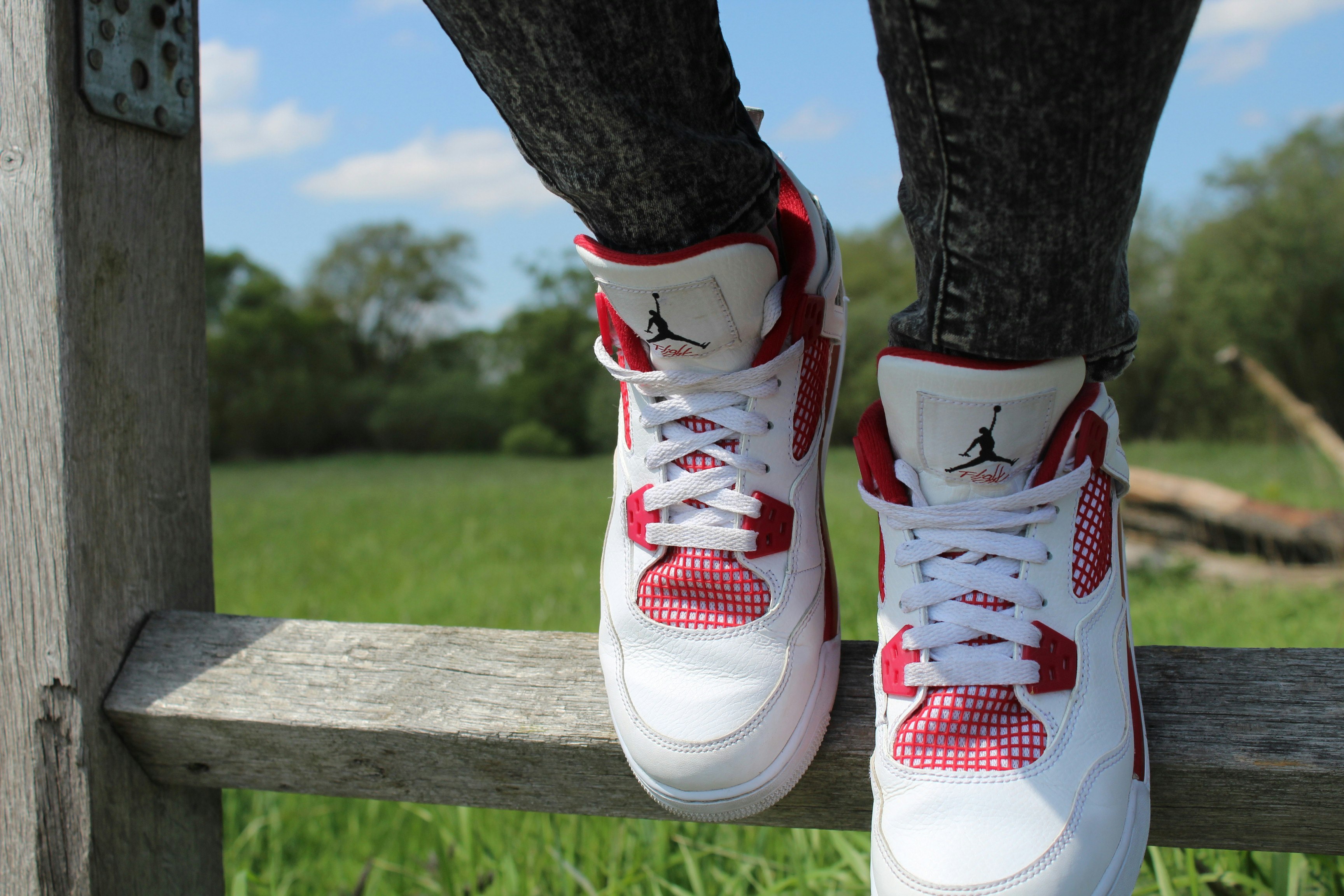 person wearing pair of red-and-white Air Jordan shoes